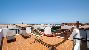 A rooftop terrace with a hammock, a pool, and a view of the sea. - Villa Anna - Beautiful exclusive Villa with pool  (Castillo Caleta de Fuste)