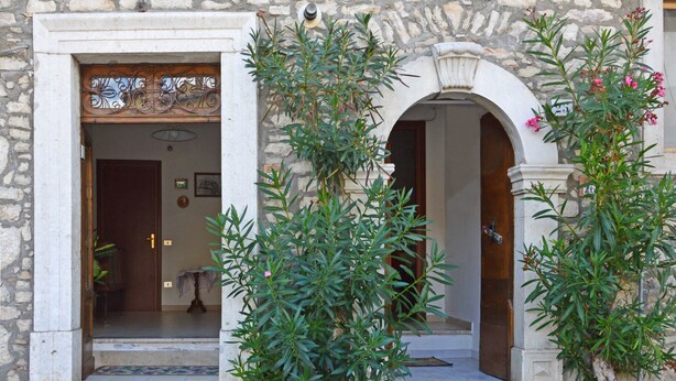 A stone building with a wooden door and an arched entrance.
