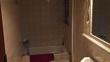 Une salle de bain avec des toilettes, un lavabo et une baignoire.