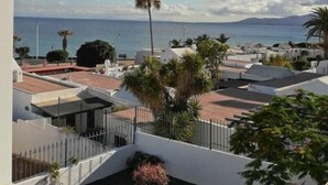 A coastal residential area with a clear view of the sea and mountains in the distance. - DORAMAS APARTMENT, Tias (Puerto del Carmen, Tias)