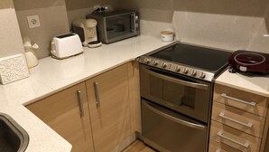 A compact kitchen with a built-in oven, a microwave, a toaster, and a coffee maker. - Central Luxury Suite. Parking Included (Vigo)