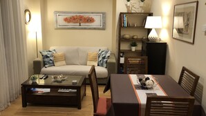 A living room with a sofa, coffee table, dining table, and bookshelf. - Central Luxury Suite. Parking Included (Vigo)