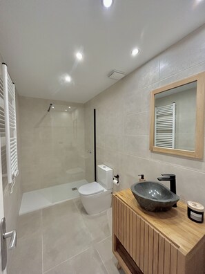 Un baño moderno con ducha, inodoro y lavamanos.