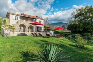 A house with a stone facade, a pool, and red umbrellas. - Village stone Villa Ana Boljun (Boljun)