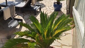 A patio area with lounge chairs, a table, and a potted plant. - fantastically located detached villa with private swimming pool for 8 people. (Callas)