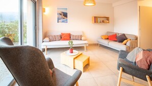 A modern living room with two sofas, a coffee table, and a bookshelf. - Facing south, garden, exceptional view, super equipped. Ideal for 2 families (Lans-en-Vercors)