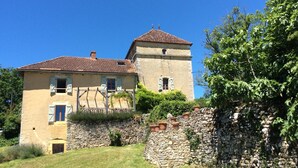 Un bâtiment à deux étages doté d’un mur en pierre et d’une tour.