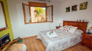 Una camera da letto con un letto, comodini, una finestra vista e un camino.