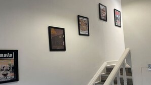 A staircase with white railings and a wall with framed pictures. - Elder Park Apartment 5 The Loft (Glasgow)