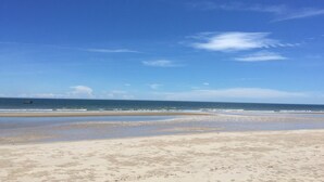Ein Strand mit blauem Himmel und ruhiger See.