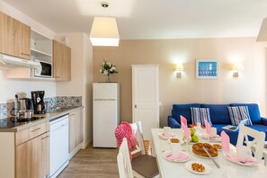 A compact living space with a kitchenette, dining area, and a sofa.