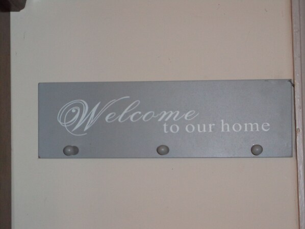 A welcome sign with the text "Welcome to our home" mounted on a wall.