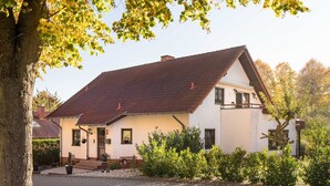 A two-story house with a sloped roof, a front porch, and a small garden area. - Vacation apartment Ziske, Germany (Bad Wildungen)