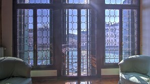A room with a large window featuring a metal grid design, two upholstered chairs, and a wooden floor. - RABOSO Grand 9~windows (Venezia)