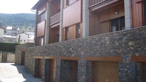 A multi-story building with wooden balconies and stone walls. - Cozy apartment in Alp with garden and parking, 10 minutes from the ski slopes! (Alp)