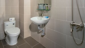 A modern bathroom with a toilet, sink, and shower.