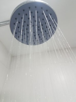 Eine Duschbrause, aus der Wasser fließt.