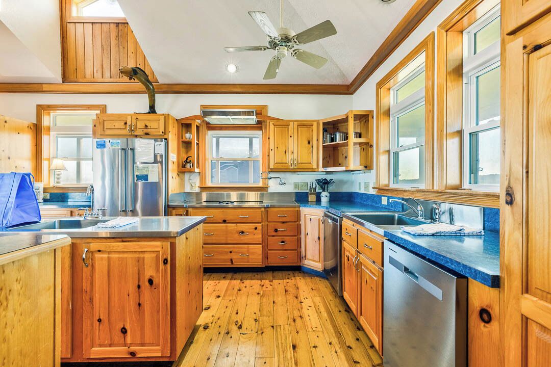 A spacious kitchen with wooden cabinets, stainless steel appliances, and a large island.