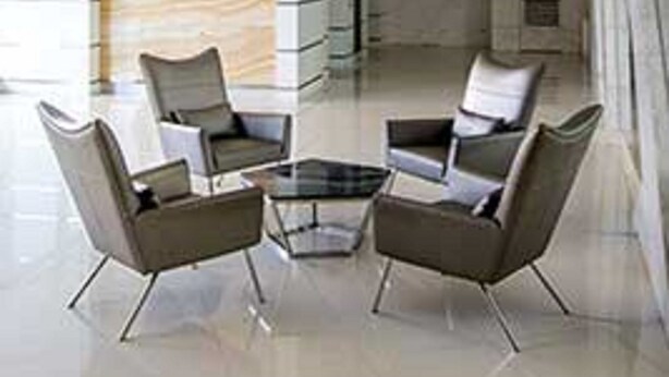 A modern lobby with a glass coffee table, two armchairs, and a patterned wall. - Cool Place Light Residences (Mandaluyong)