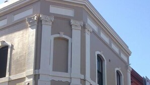 A building with a classical architectural style, featuring a symmetrical facade with columns and a central entrance. - Sinclairs City Hostel (Surry Hills)