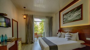 Een slaapkamer met een groot bed, een houten hoofdeinde, een schilderij en een balkon met gordijnen.