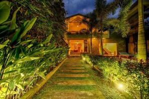 A pathway leading to a building with a covered entrance and a pool area visible to the right. - Deltora Boutique Hotel (Galle)