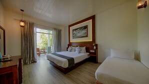 Een hotelkamer met een groot bed, een kleiner bed, een bureau en een stoel.