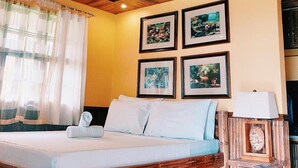 A room with a bed, wooden ceiling, and four framed pictures on the wall. - Villa Anastacia White Beach Puerto Galera (Puerto Galera)