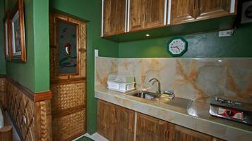 Una cocina con armarios de madera, encimera de mármol y un reloj en la pared.