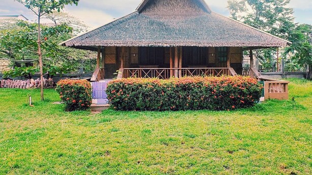 A traditional thatched-roof hut with a wooden porch and a well-maintained garden in front. - Villa Anastacia White Beach Puerto Galera (Puerto Galera)