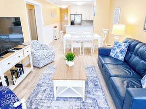 Un salon moderne avec un canapé, une table basse et un téléviseur.