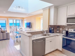 A modern kitchen with a dishwasher, stove, and microwave.
