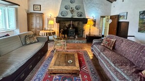 Un salon de style rustique, doté d’une cheminée, de meubles en bois et de tapis à motifs.