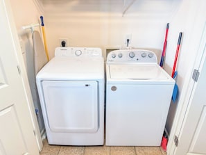 A laundry room with two white front-loading washing machines and a dryer.