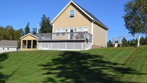 A two-story house with a balcony, a fenced yard, and a small shed. - River Front Property With Water View, Minutes To Brackley, & Screened In Dining (Oyster Bed)