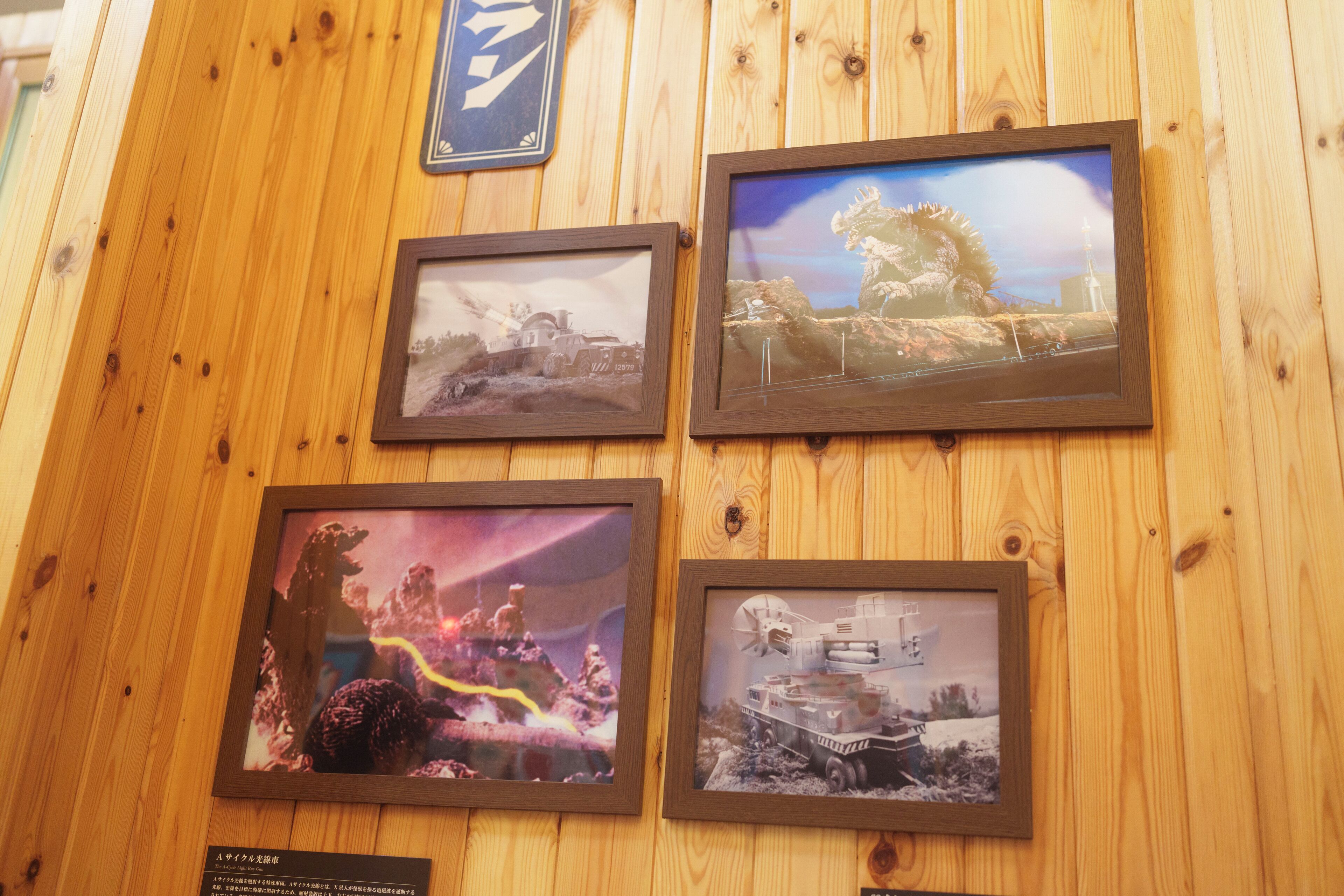Four framed pictures on a wooden wall.
