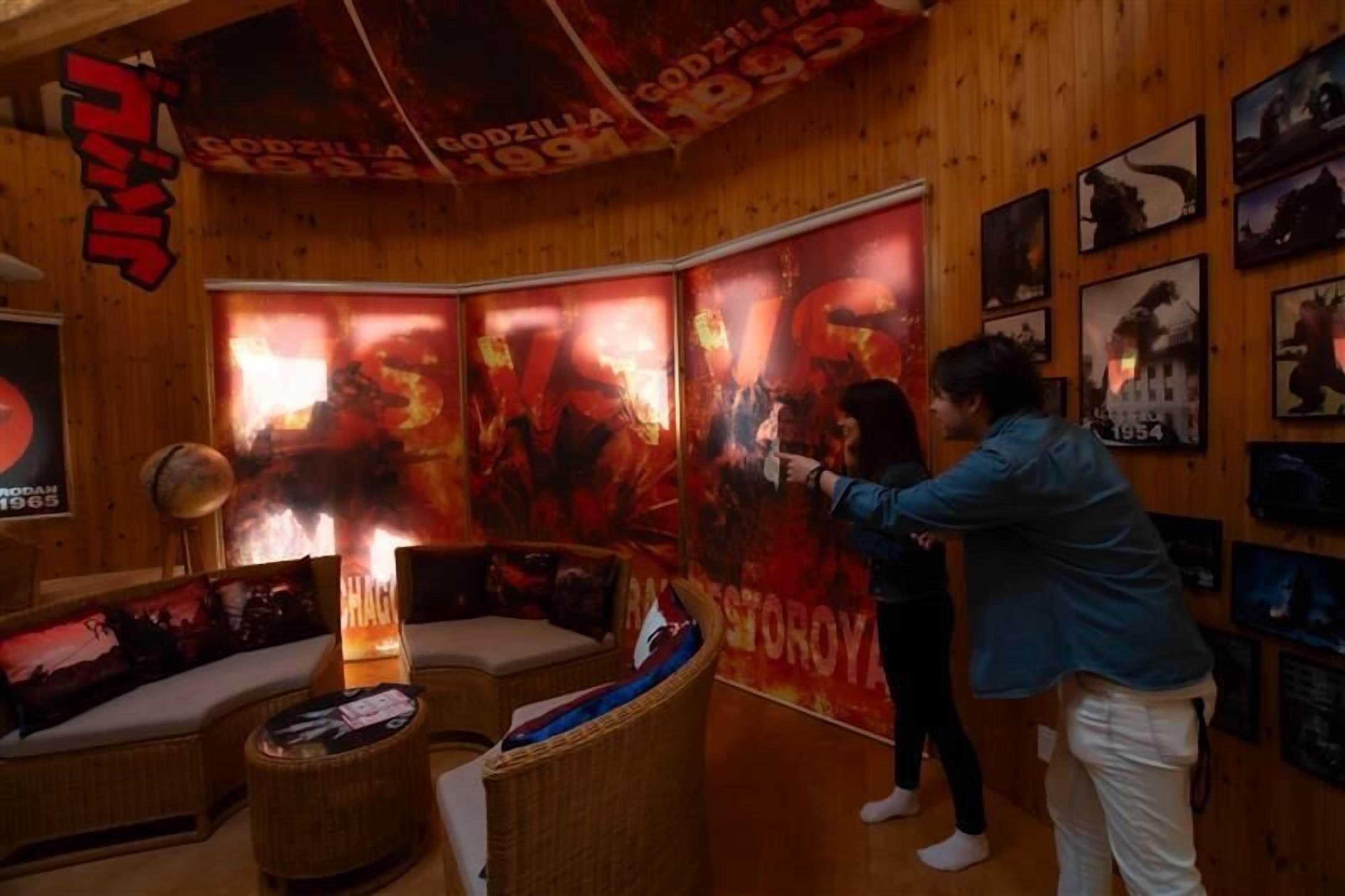 A room with a large poster of a movie, a sofa, and a lamp.