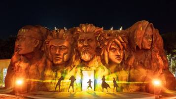 Een groot buitensculptuur met meerdere figuren en een centrale doorgang.