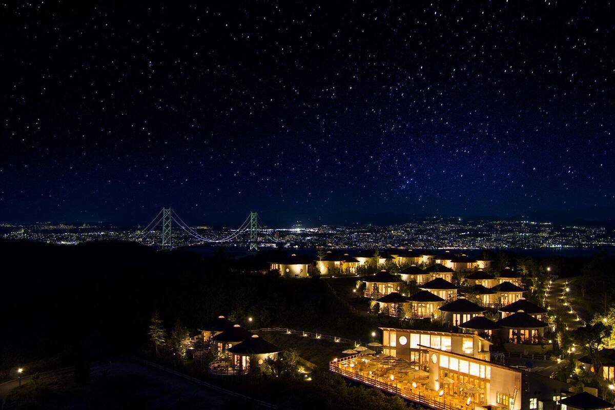 Un hôtel composé de plusieurs bâtiments, offrant une vue sur le paysage urbain et avec un pont en arrière-plan.