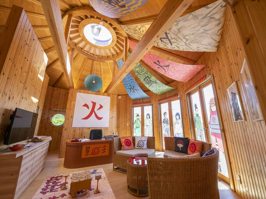 A wooden interior with a reception desk, seating area, and large windows.