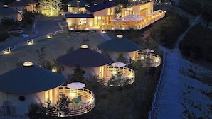 Un resort con varias estructuras en forma de cúpula, un edificio principal y un camino de acceso a las construcciones.