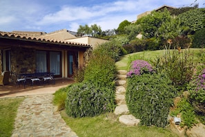 Un sendero de piedra que lleva a un patio con mobiliario exterior.