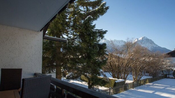 A balcony with a view of snow-covered ground and a mountain in the background. - Bergspitze (Garmisch-Partenkirchen)