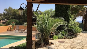A pool area with stone flooring, a pergola, and a view of the sea. - Peaceful charming paradise, beach at 70m, private swimming pool,  plancha (La Seyne-sur-Mer)