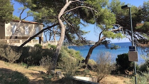A coastal building with a stone facade, a balcony, and a view of the sea. - Peaceful charming paradise, beach at 70m, private swimming pool,  plancha (La Seyne-sur-Mer)