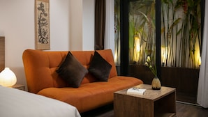 A modern living room with an orange sofa, a wooden coffee table, and a framed artwork on the wall. - The Bloom Pham Viet Chanh - Modern Living Space in Saigon - A Top Choice for Western Travelers (Ho Chi Minh City)