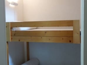 A bunk bed with a wooden frame and a white mattress.