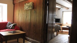 A cozy room with a wooden wall, a sofa, a table, and a television. - apartment/ flat - LAPOUTROIEHouse with character (Lapoutroie)