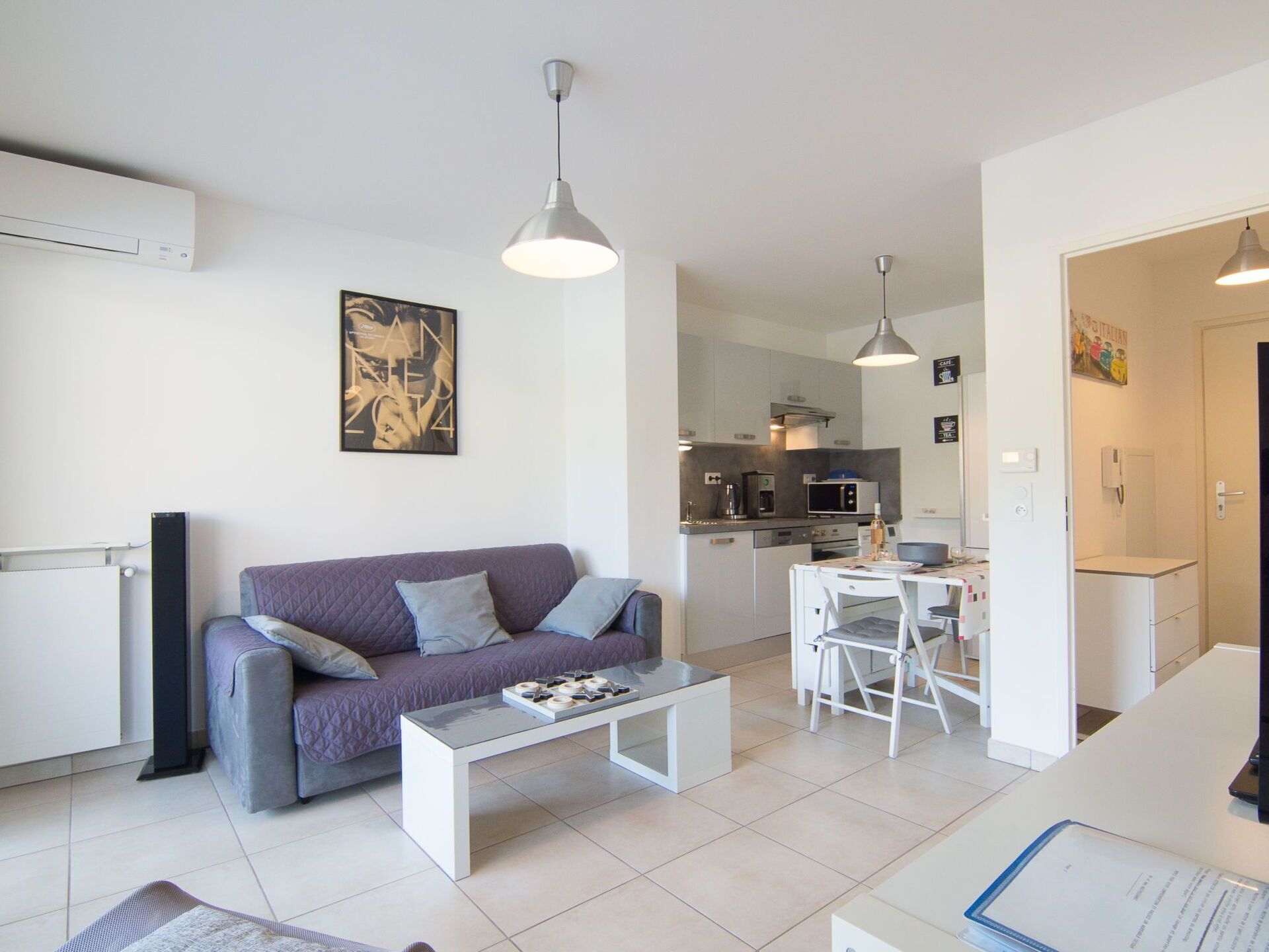 A modern apartment with a living area, kitchen, and dining space.