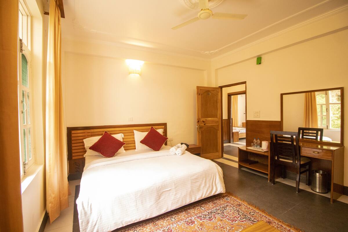 Una camera d'albergo con un letto, una scrivania, una sedia e uno specchio grande.